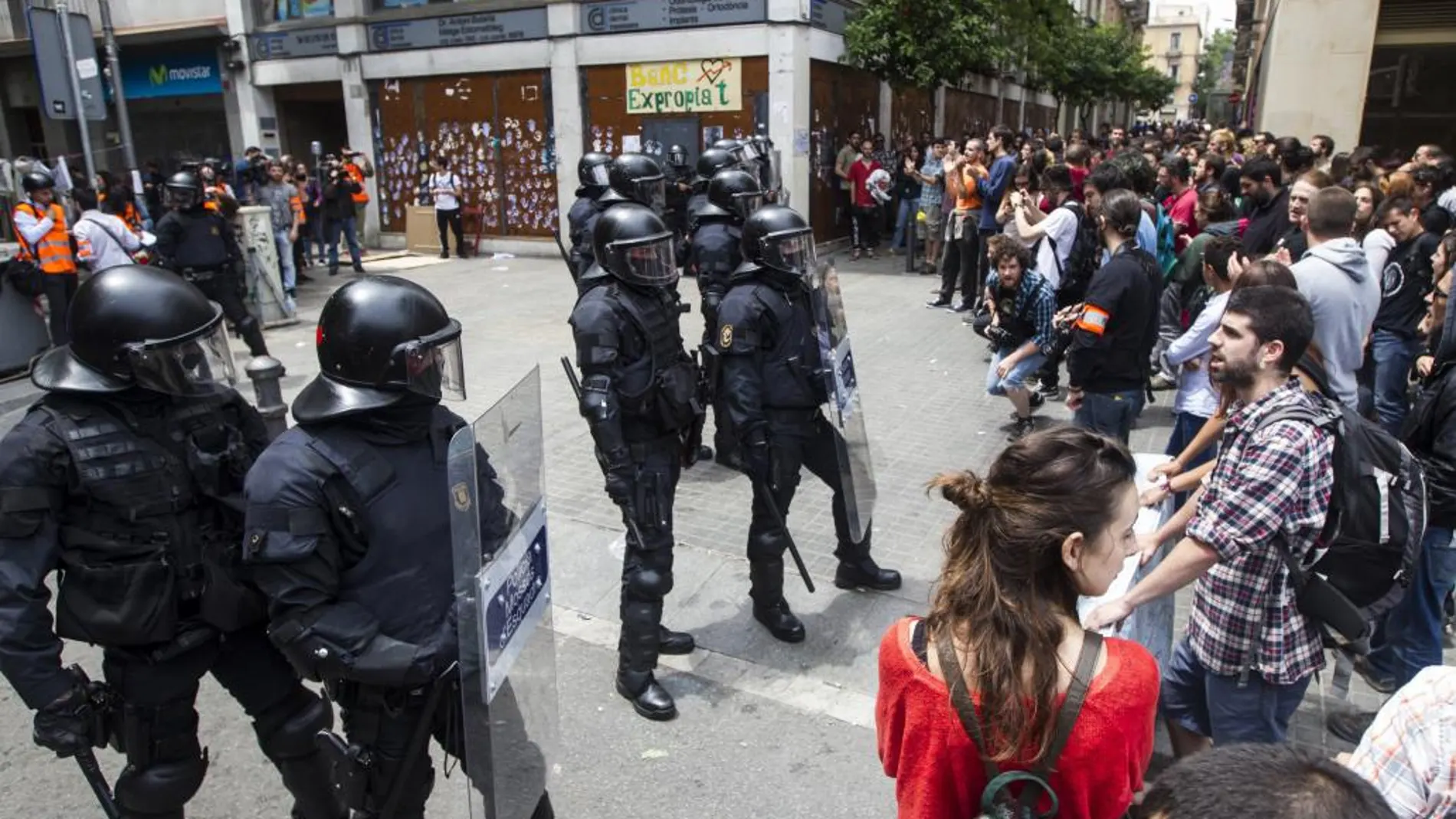 Agentes antidisturbios de los Mossos rodean los accesos del llamado «Banco Expropiado» de Barcelona, el sábado
