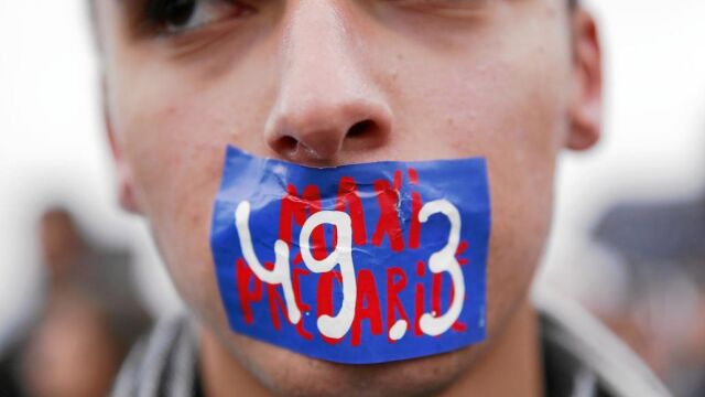 Participantes de las concentraciones contra la reforma de la ley laboral protestan con un adhesivo con el 49.3 pintado