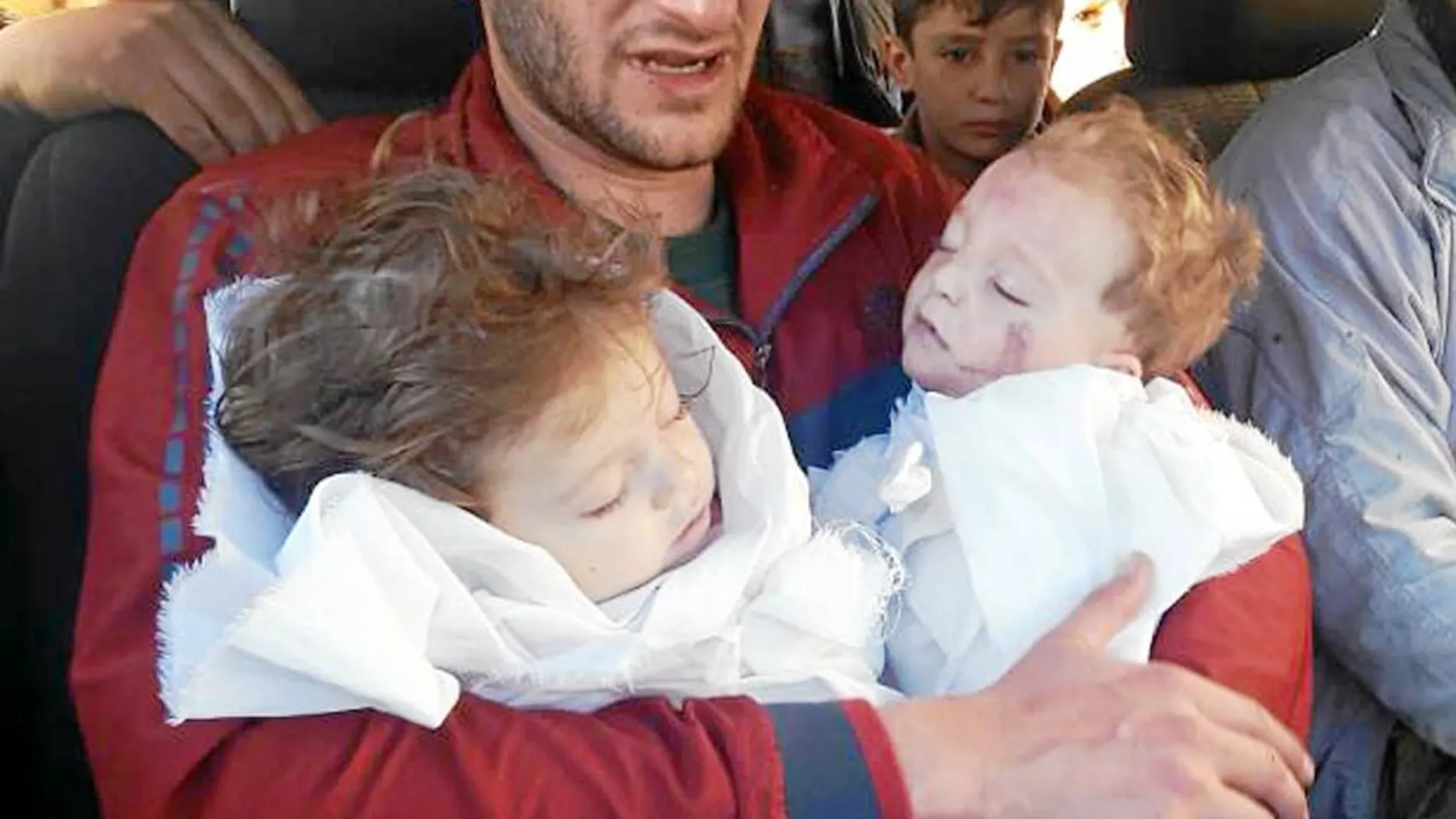 Un padre abraza a sus dos hijos fallecidos en el ataque químico del martes en Idlib