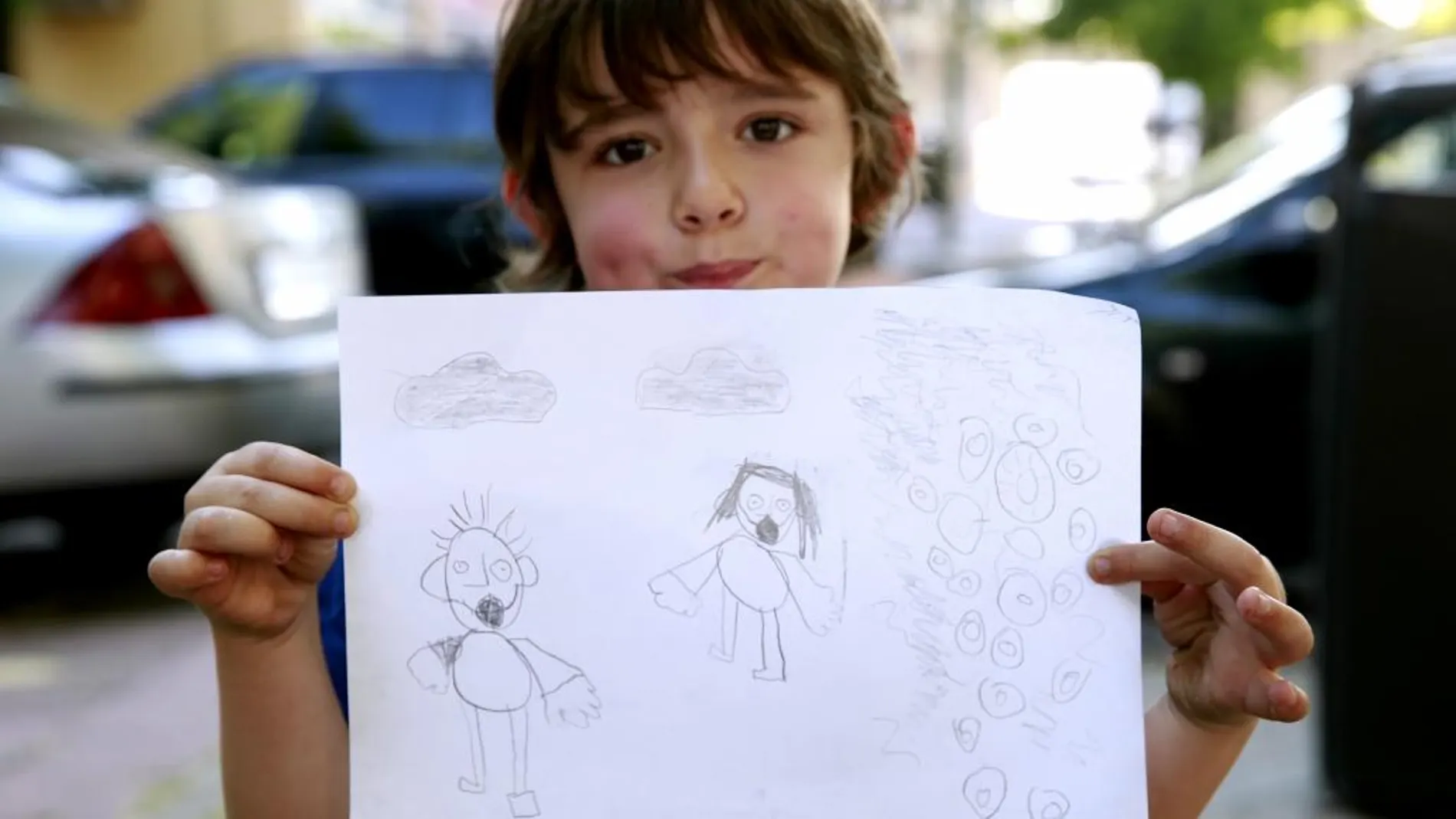 Aday muestra su dibujo de sus padres, con mascarillas y una columna de humo