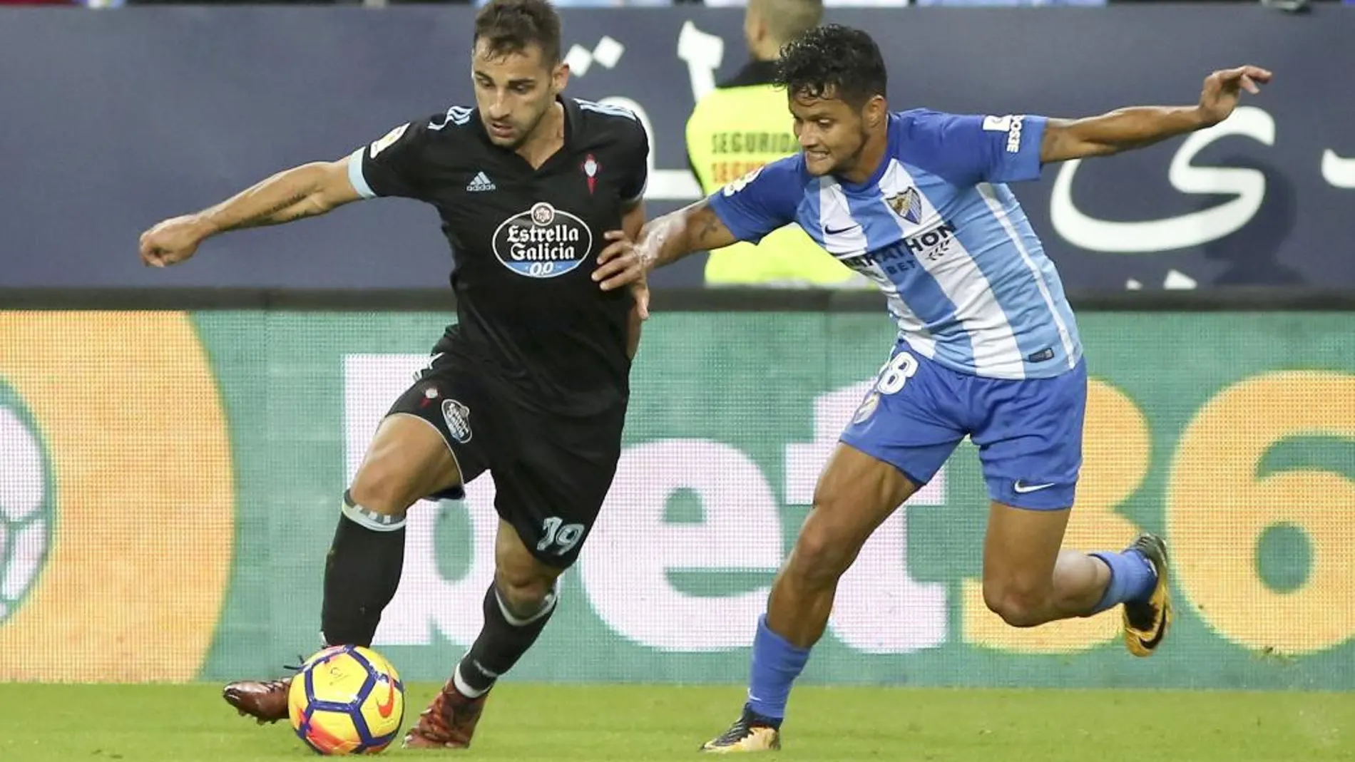 El defenda del Celta, Jonathan Castro "Jonny"(i), se lleva el balón ante el jugador venezolano del Málaga, Roberto José Rosales