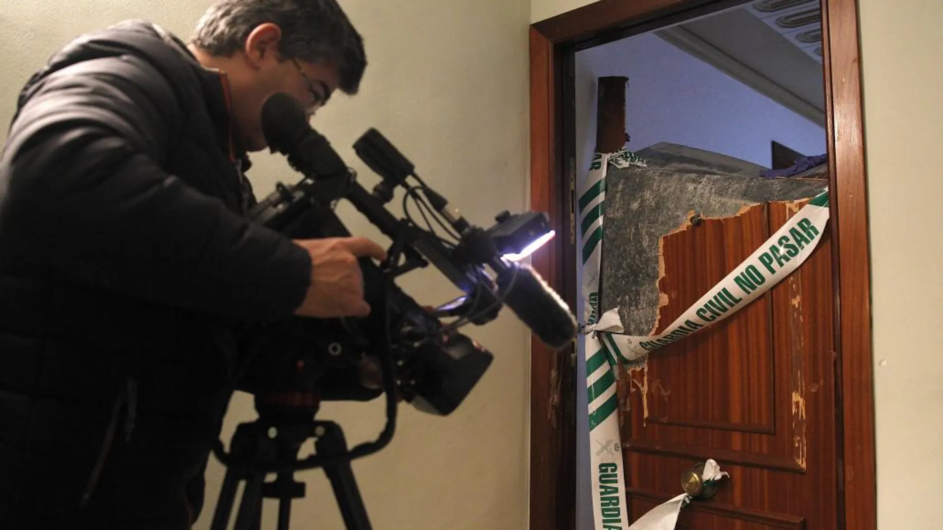 Un operario de televisión graba el portal de la vivienda en la que ha sido hallada una niña de tres años con un cuchillo clavado en el tórax