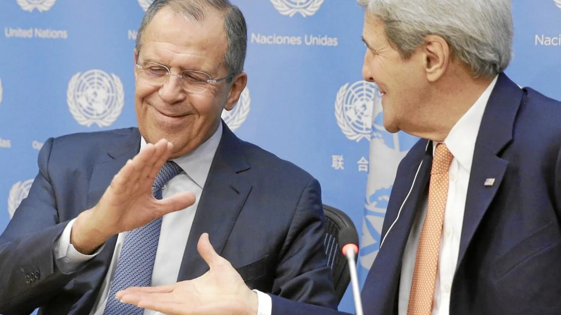 Sergei Lavrov (Rusia) y John Kerry (EE UU) chocan las manos en la rueda de prensa