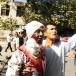 Un hombre ayuda a un herido tras la explosión de un coche bomba en Kabul (Afganistán)