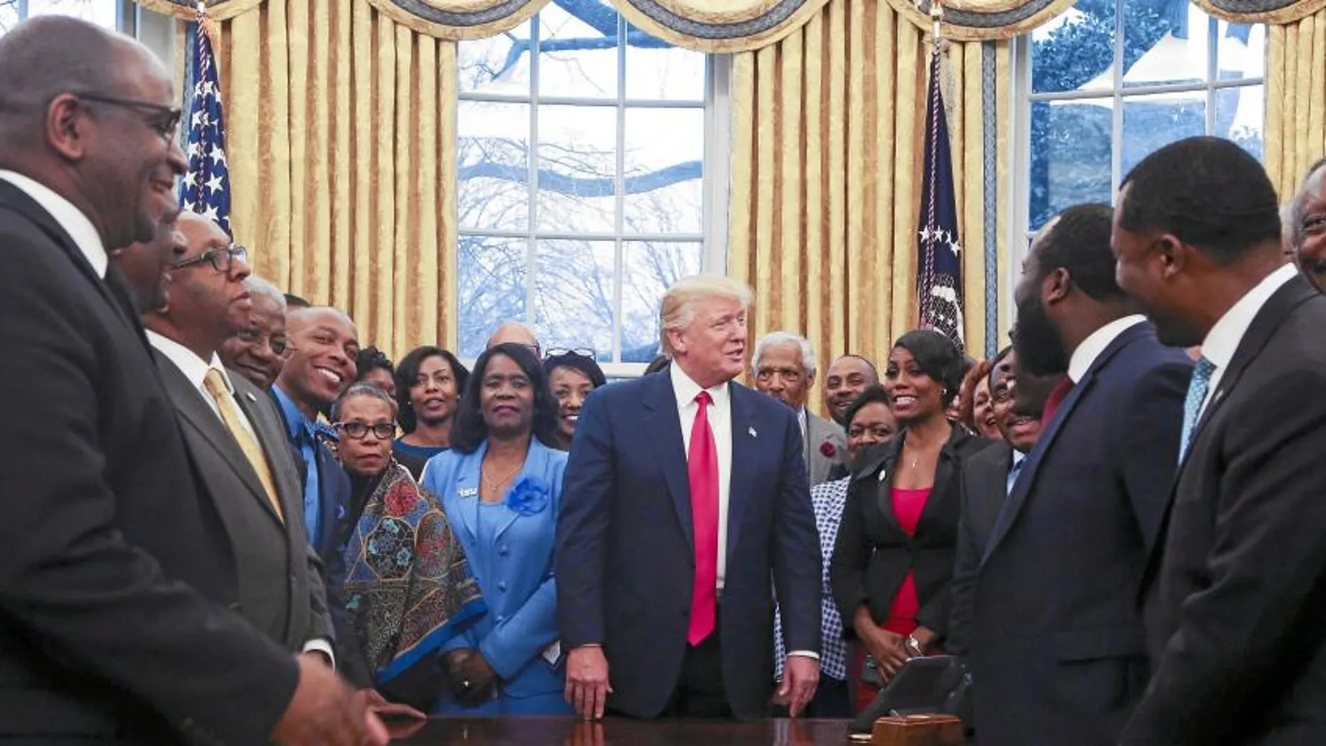 Donald Trump posa con un grupo de representantes negros de colegios y universidades, ayer, en el Despacho Oval