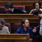 El diputado de IU, Alberto Garzón (d) conversa con el líder de Podemos, Pablo Iglesias