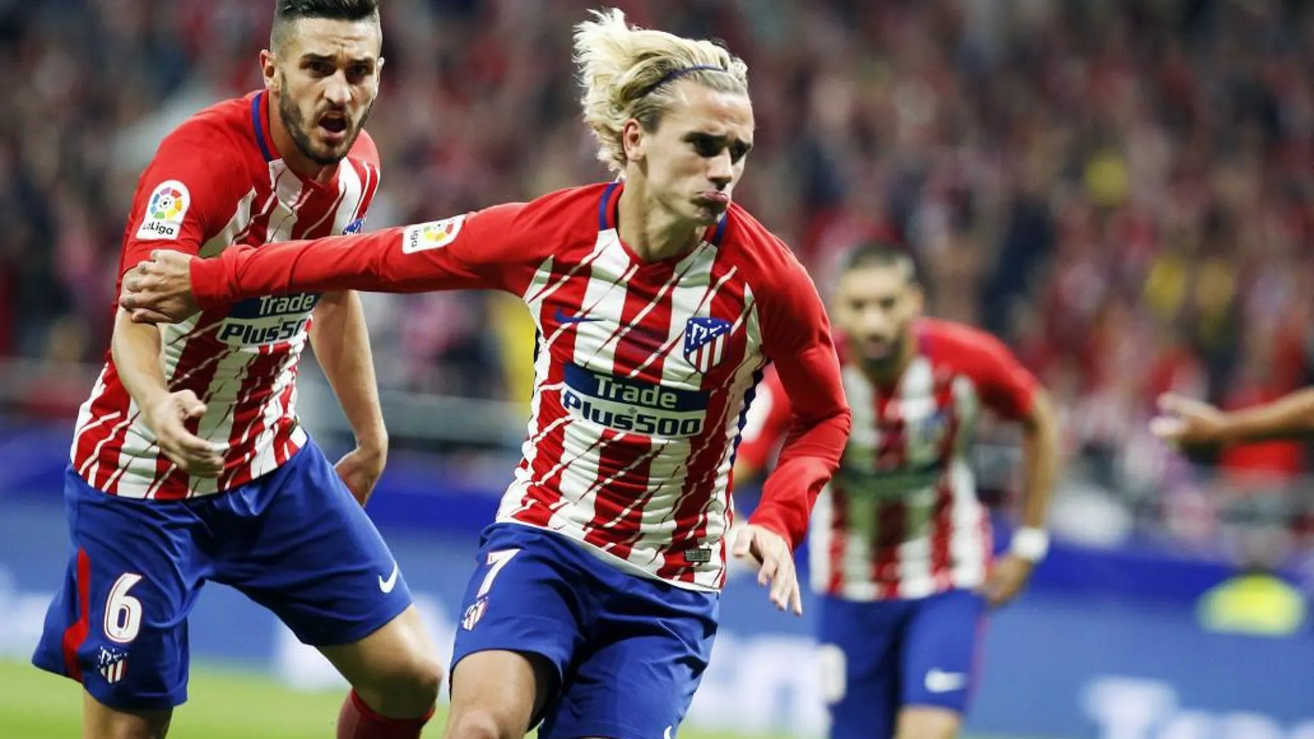 Antoine Griezmann (d) celebra tras marcar ante el Málaga, durante el partido de Liga en Primera División que se disputa esta noche en el estadio Wanda Metropolitano, en Madrid.