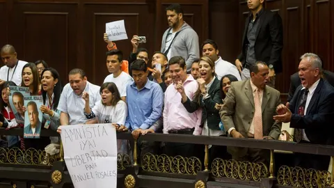Familiares de presos políticos muestran afiches en el palco de invitados del hemiciclo de sesiones de la Asamblea Nacional hoy, jueves 4 de febrero.
