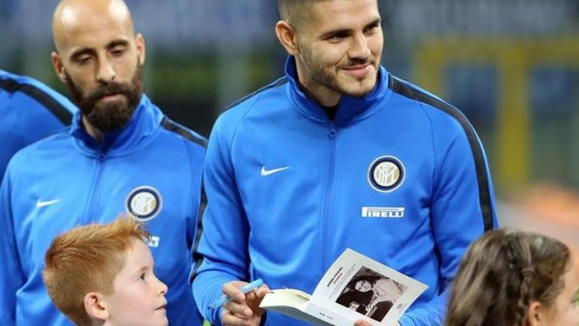 El capitán del Inter, Mauro Icardi, firma una copia de «El diario de Ana Frank» para un niño antes de un partido