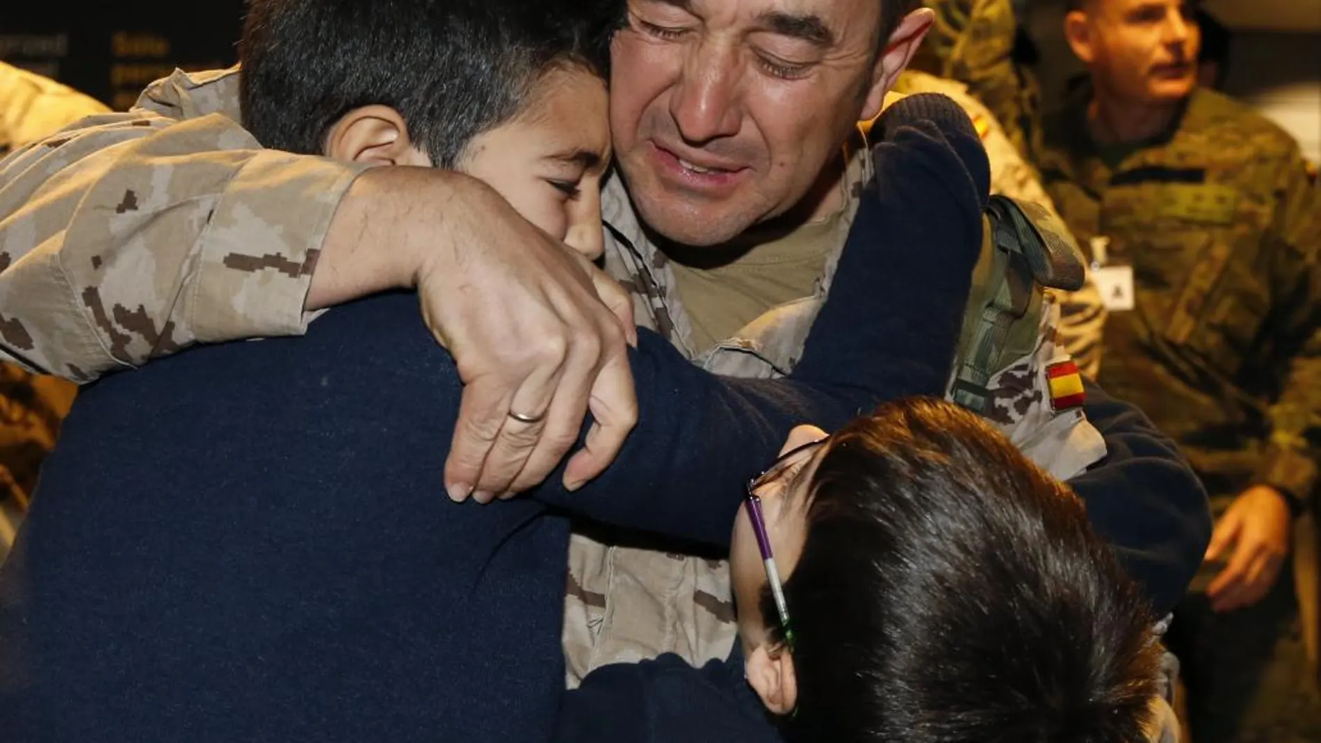Un efectivo de la Brigada Paracaidista abraza a sus hijos tras aterrizar