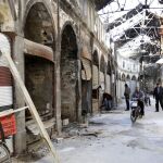 Varios comerciantes arreglan sus tiendas en el mercado de la ciudad antigua de Homs que ha vuelto a manos del Gobierno sirio