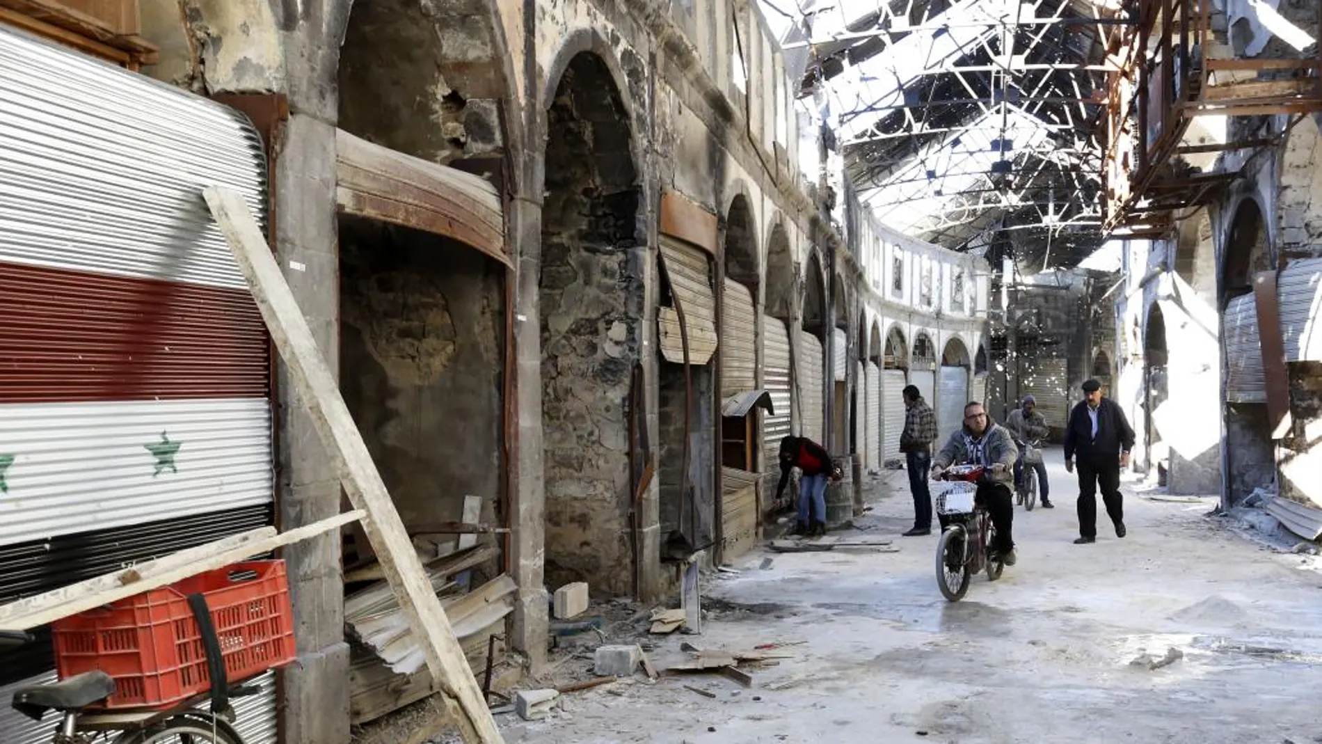 Varios comerciantes arreglan sus tiendas en el mercado de la ciudad antigua de Homs que ha vuelto a manos del Gobierno sirio