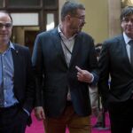 El presidente de la Generalitat de Cataluña, Carles Puigdemont, se dirige junto al director general de Comunicación de la Generalitat, Jaume Clotet, y el conseller de la Presidencia, Jordi Turull