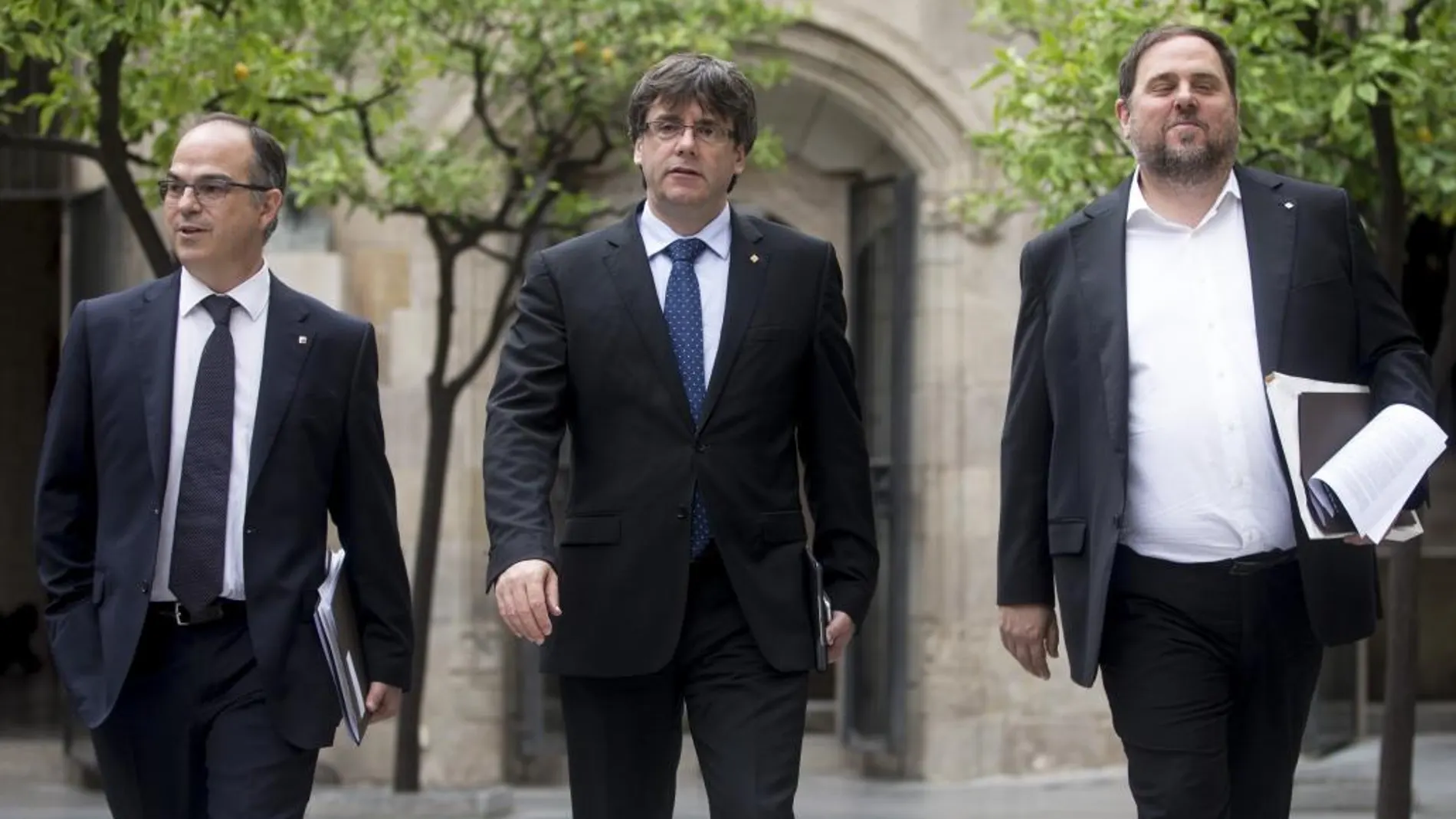 El presidente de la Generalitat , Carles Puigdemont (c), el vicepresidente del Govern y conseller de Economía, Oriol Junqueras (d), y el conseller de la Presidencia, Jordi Turull (i)