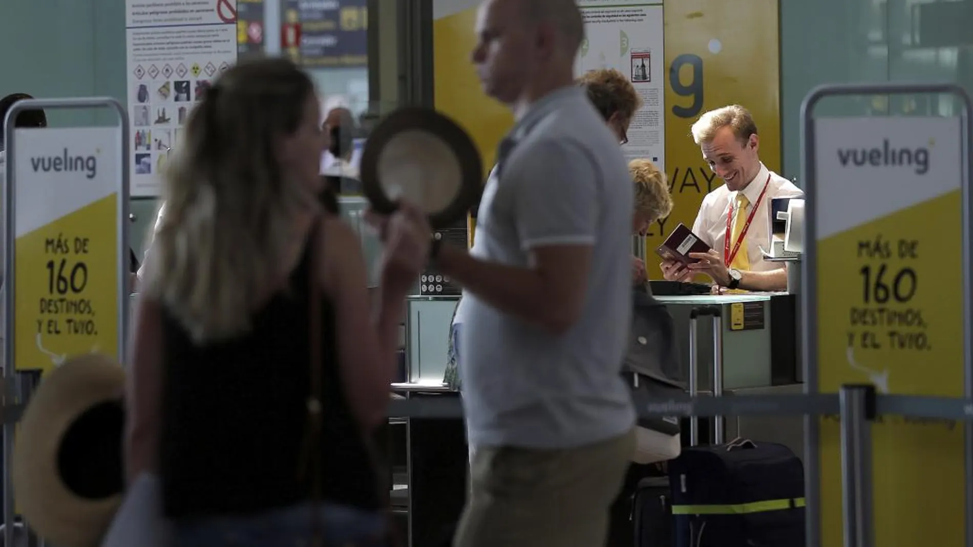 Personal de facturación de Vueling atiende a los viajeros en el Aeropuerto de El Prat.