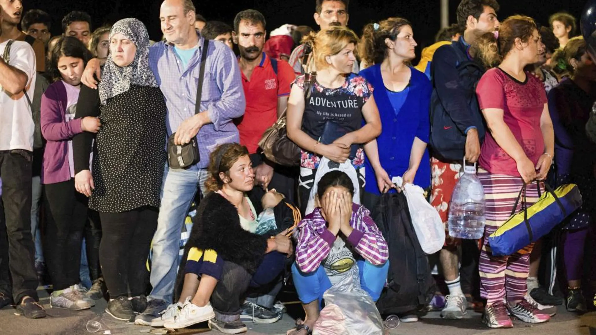 Refugiados esperan en una calle de Tovarnik (Croacia)