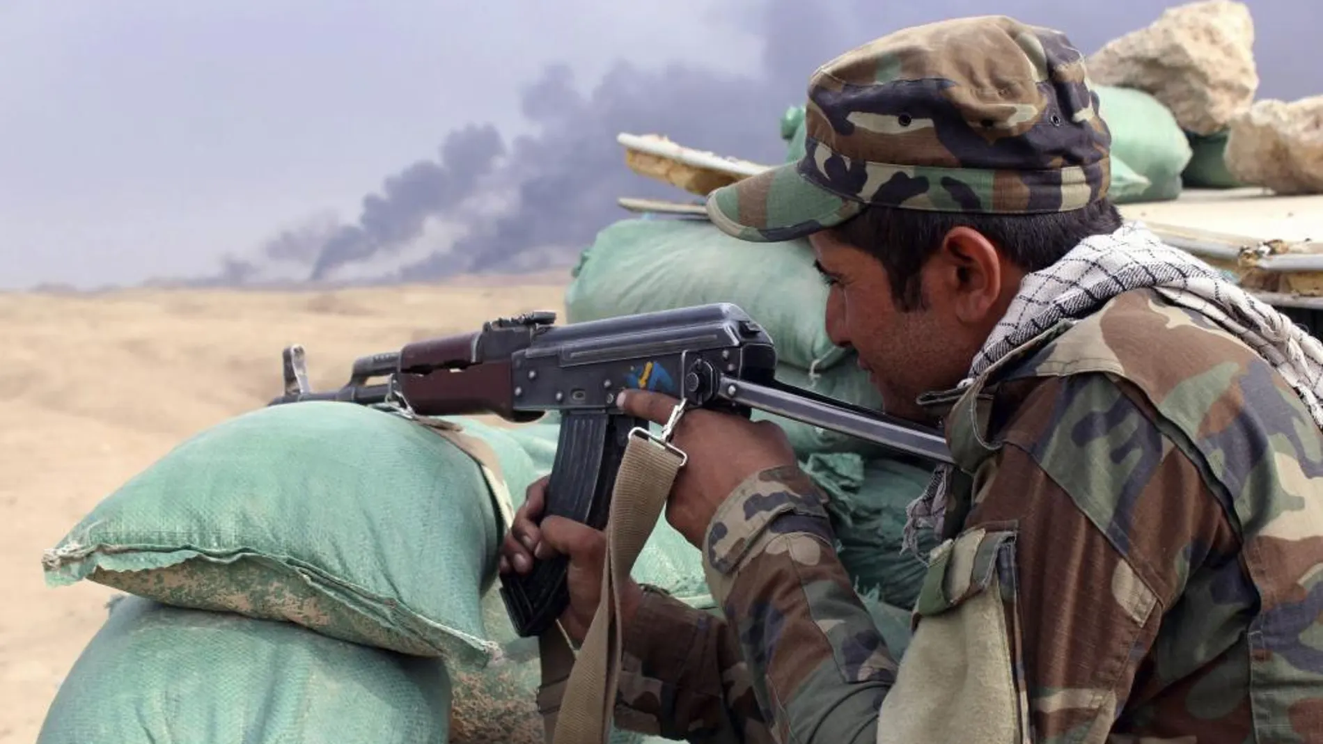 Un soldado iraquí apunta con su arma durante los enfrentamientos entre combatientes del Estado Islámico (EI) y las fuerzas iraquíes en las proximidades de la ciudad de Baiji (norte de Irak), hoy, 22 de octubre de 2015.