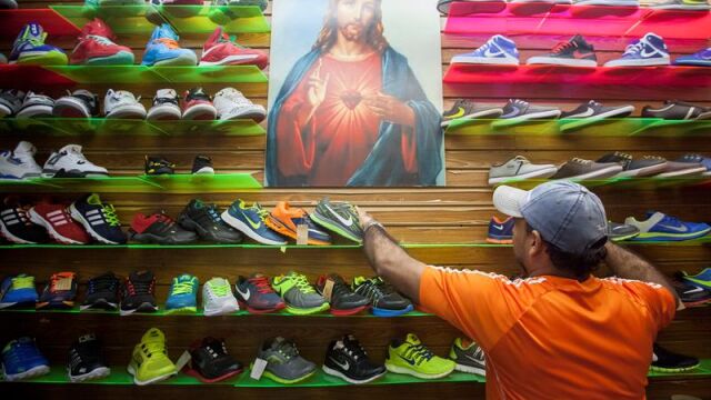 Un vendedor arreglando la mercancía en un puesto del mercado popular La Hormiga ubicado en el sur de Caracas (Ve
