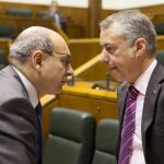 El lehendakari, Iñigo Urkullu (d), y el consejero vasco de Salud, Jon Darpón (i), conversan en el Parlamento Vasco.