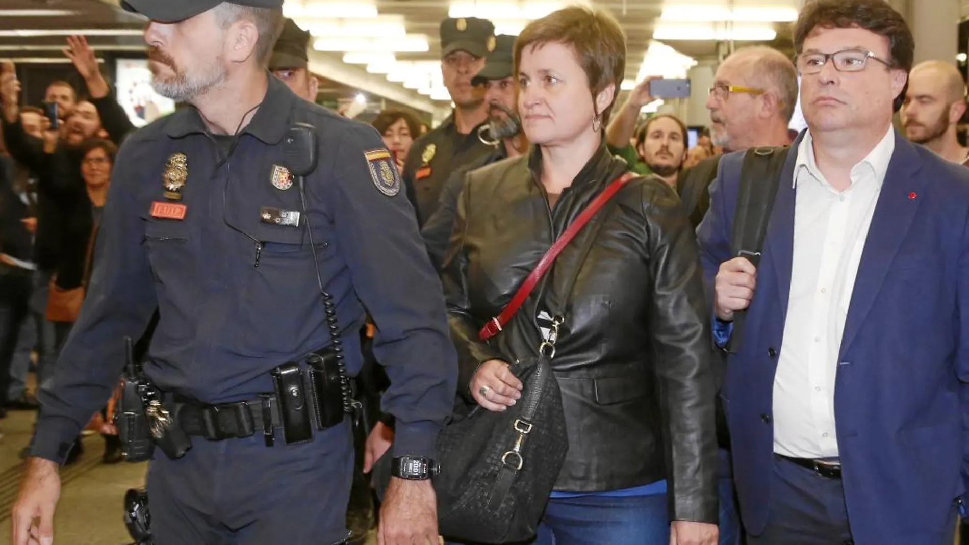 Anna Simó y Joan Josep Nuet, miembros de la disuelta Mesa del Parlament, a su llegada, ayer, a la estación de Atocha escoltados por la Policía Nacional