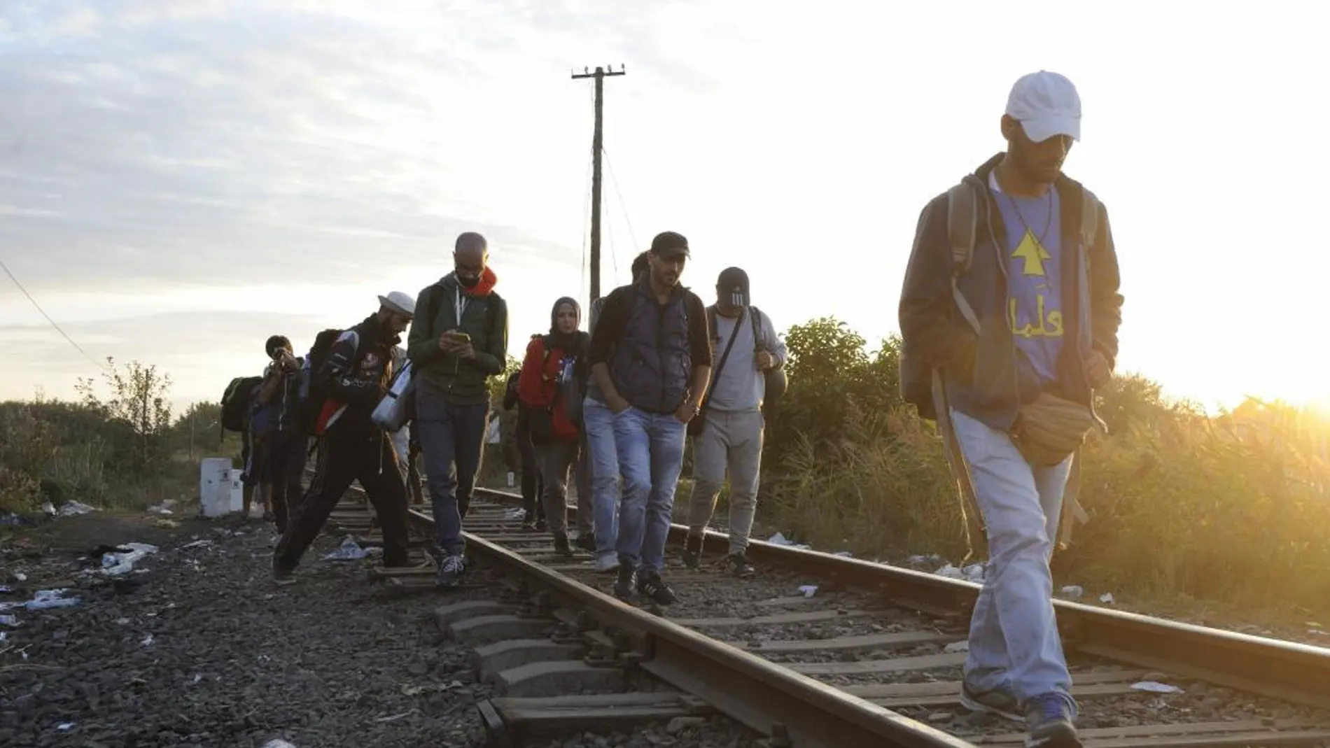 Inmigrantes caminan junto a una línea de tren que conecta a Horgos y Szeged en las proximidades de la frontera entre Hungría y Serbia, cerca a la frontera Roszke, a unos 180 km de Budapest