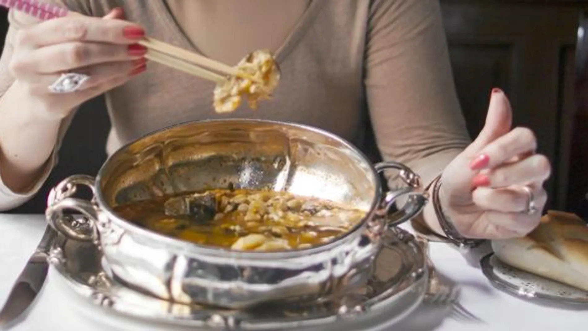 Una comensal degusta un potaje de vigilia en el restaurante Lhardy