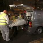 Miembros del servicio funerario de Vigo introducen en un vehículo uno de los el cadáveres de la pareja de nacionalidad portuguesa