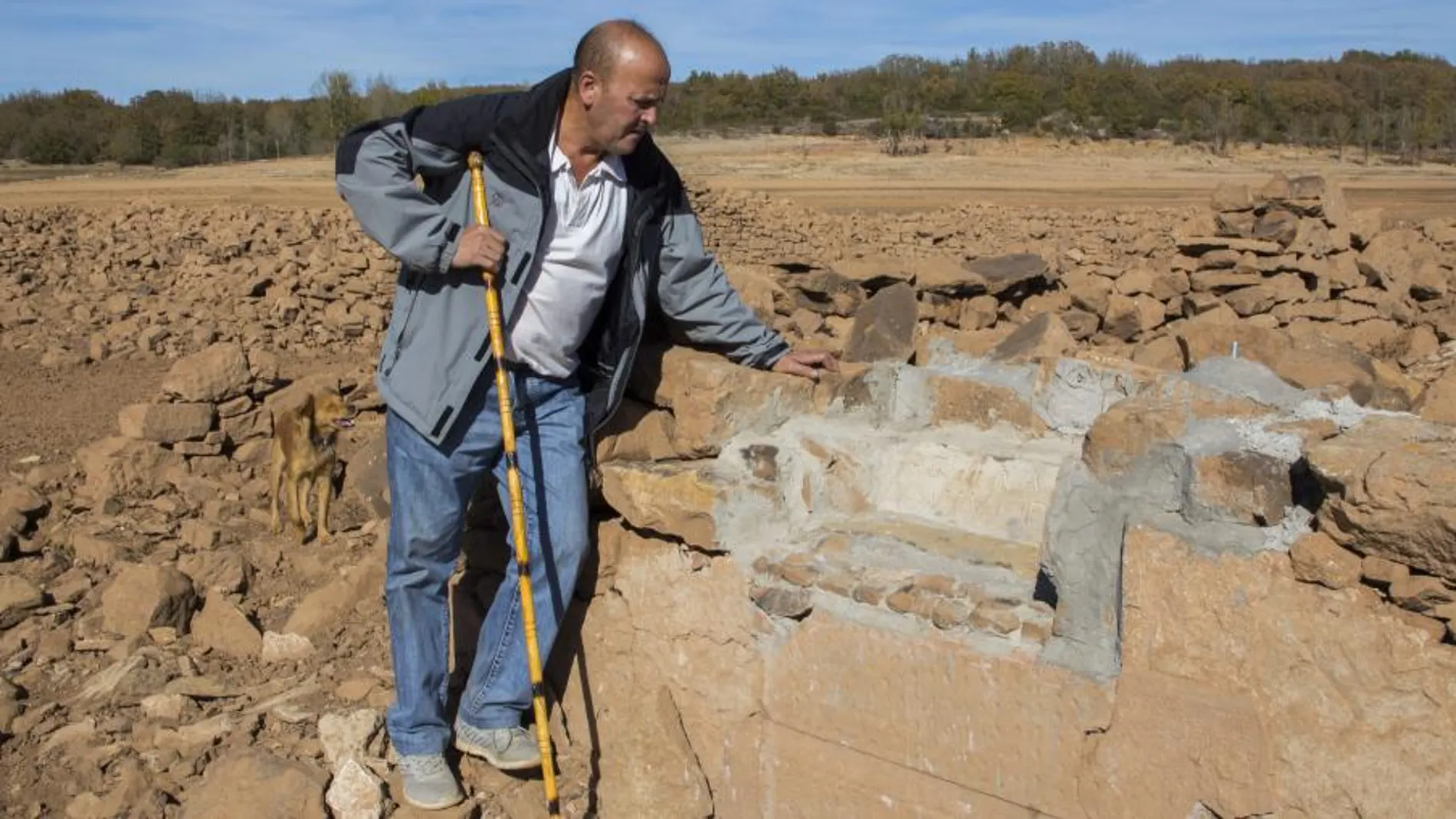 José de Salinas lee una frase escrita en hormigón en una de las casas por un antiguo vecino del pueblo Villanueva del Río que dice: «Aquí nací y viví, pero me echaron. No te olvido»