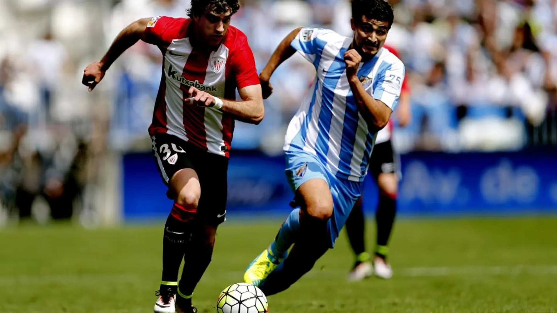 El jugador del Athletic Club de Bilbao, Iñigo Lekue (i), lucha por el balón ante el centrocampista uruguayo del Málaga, Chory Castro, durante el partido correspondiente a la trigésima tercera jornada de Liga de Fútbol.
