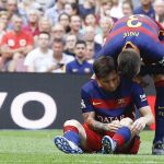 El delantero argentino del FC Barcelona Leo Messi es animado por Gerad Piqué después de lesionarse