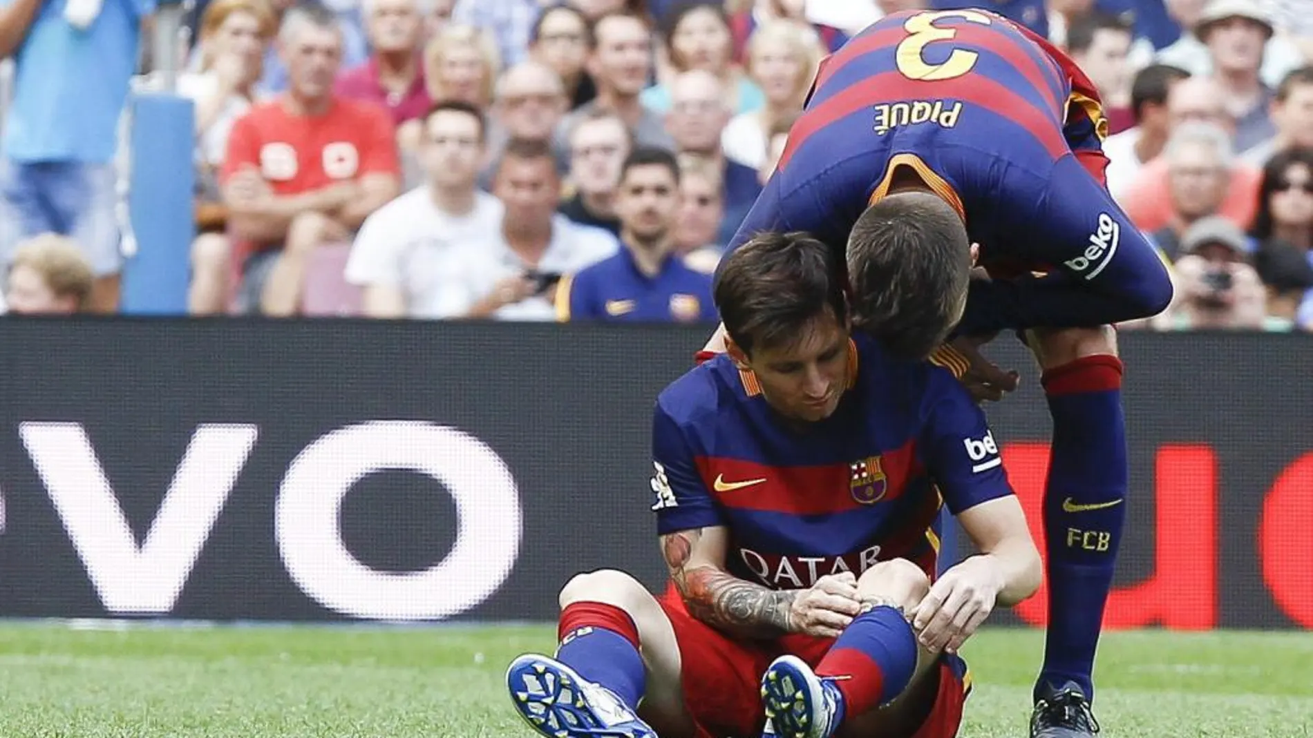 El delantero argentino del FC Barcelona Leo Messi es animado por Gerad Piqué después de lesionarse
