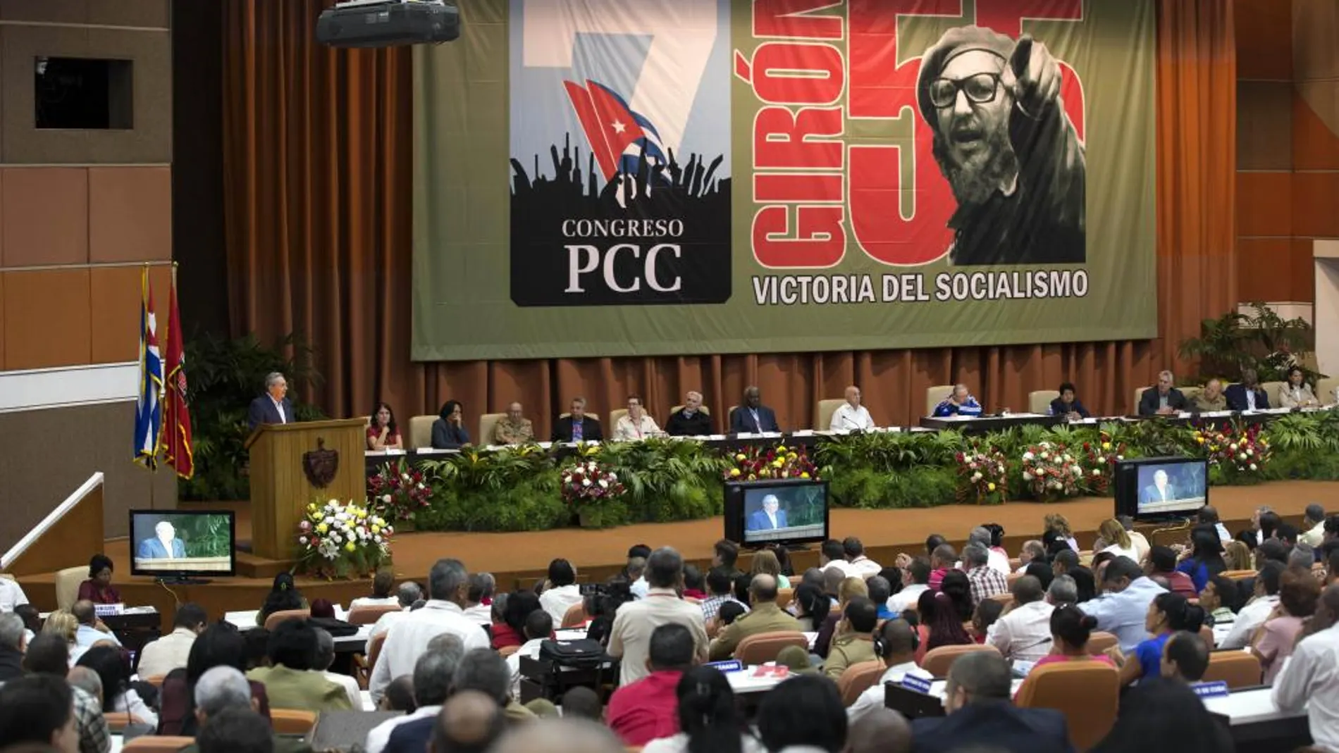 Fidel Castr escucha a su hermano Raúl durante el congreso del PPC