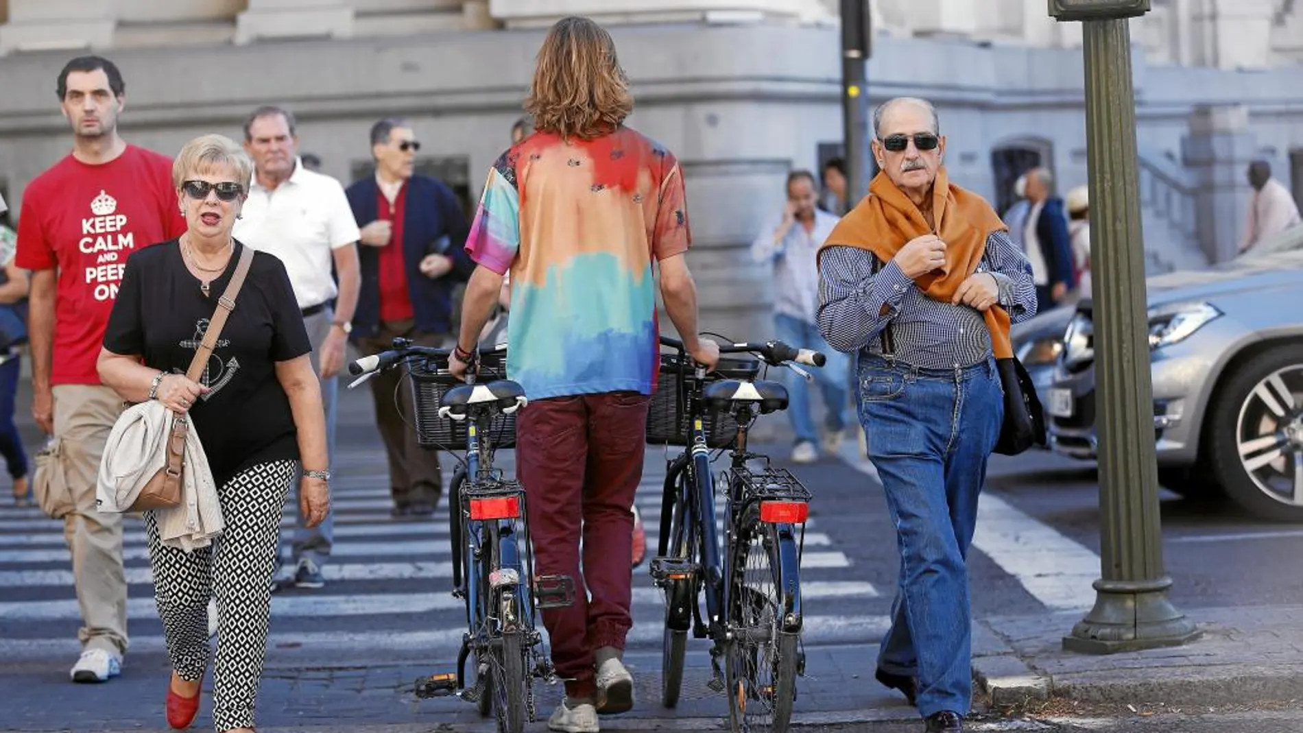 Uno de los participantes ayer en la actividad de la bicicleta del Paseo del Prado, cruzando en el paso de peatones con Alcalá