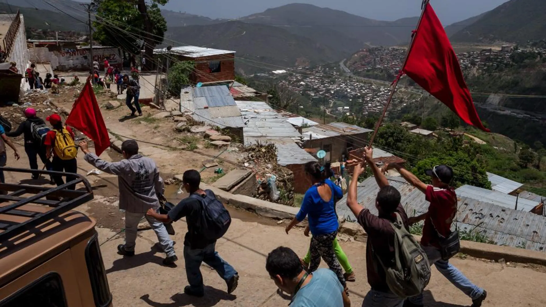 Miembros de la Fuerza Armada Nacional Bolivariana (FANB) y civiles ondean banderas rojas durante ejercicios militares en un barrio al oeste de Caracas (Venezuela)