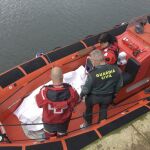 Agentes de la Guardia Civil y miembros de Cruz Roja junto al cuerpo sin vida del buceador que se buscaba desde esta mañana, por tierra, mar y aire, en la costa de Suances.