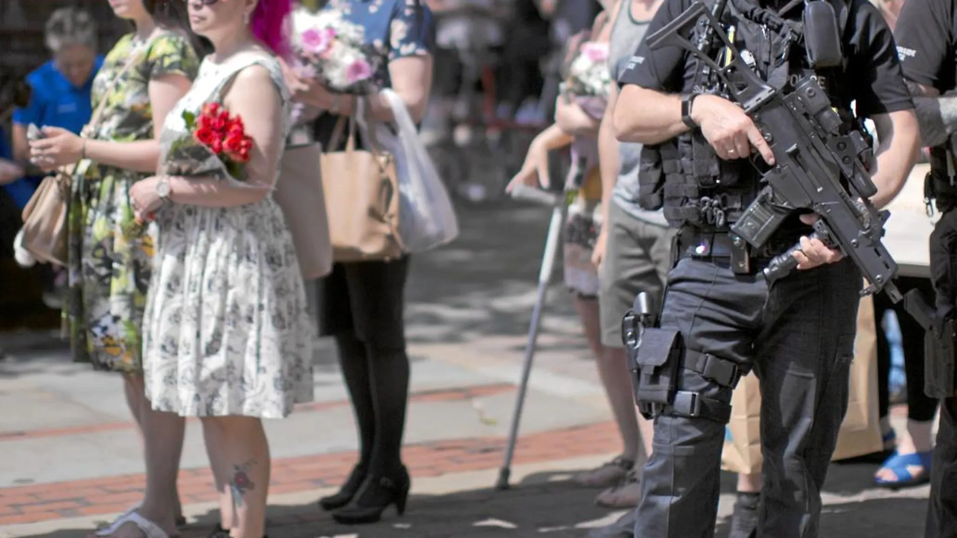 Policías escoltan a los que se dirigen con flores al lugar del atentado