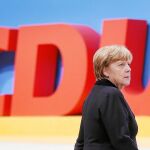 Angela Merkel junto a las siglas de su partido, ayer antes de su discurso