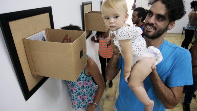 El grafitero cubano Danilo Maldonado, sostiene a su hija en una exposición en La Habana el 29 de abril de 2014