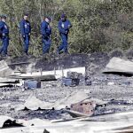Una patrulla policial inspecciona los restos del incendio del campamento de Grande-Synthe