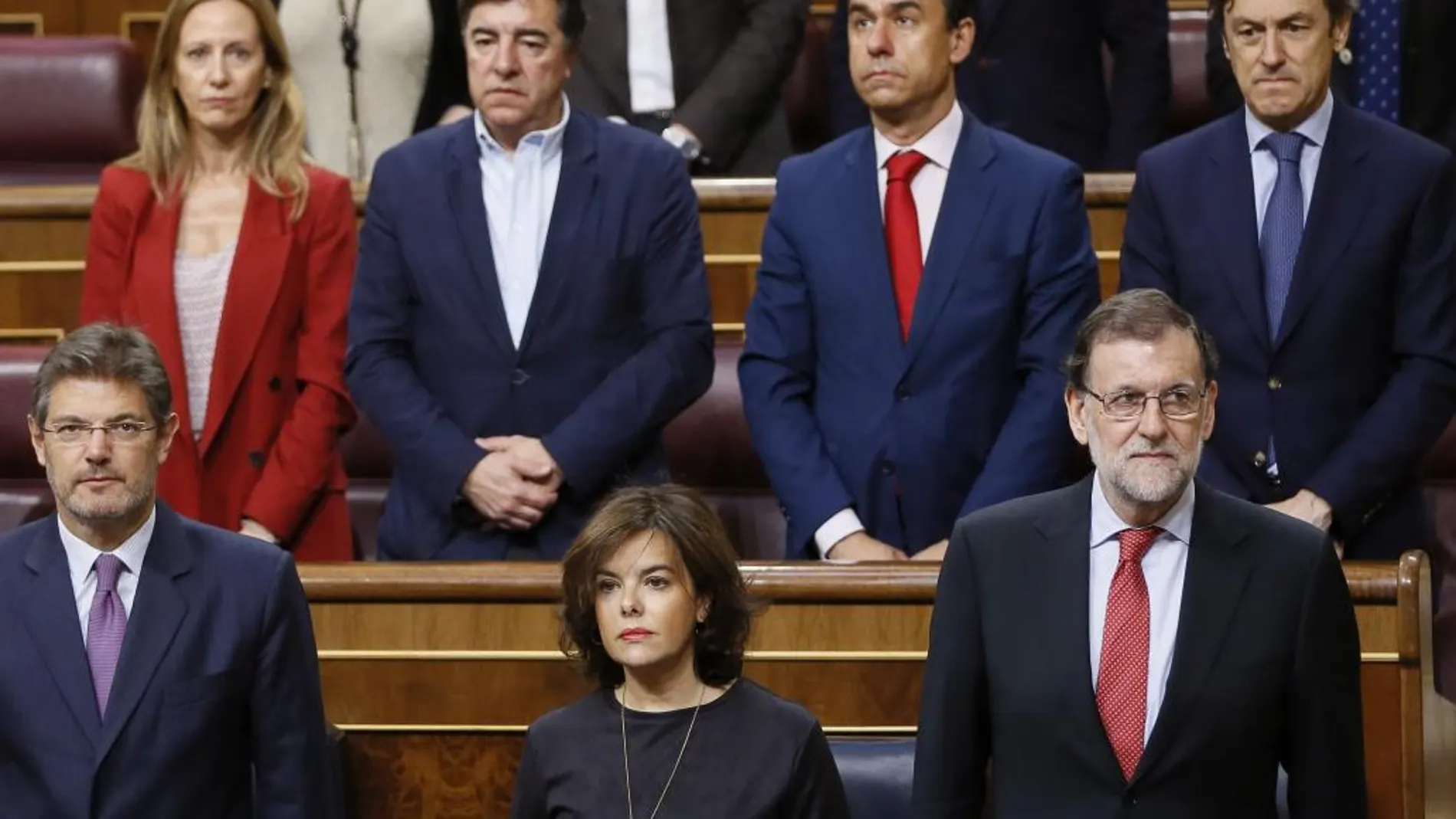 El presidente del Gobierno, Mariano Rajoy (d), la vicepresidenta, Soraya Sáenz de Santamaría (c), el ministro de Justicia, Rafael Catalá (i), y varios diputados del PP, durante el minuto de silencio en memoria de Miguel Ángel Blanco