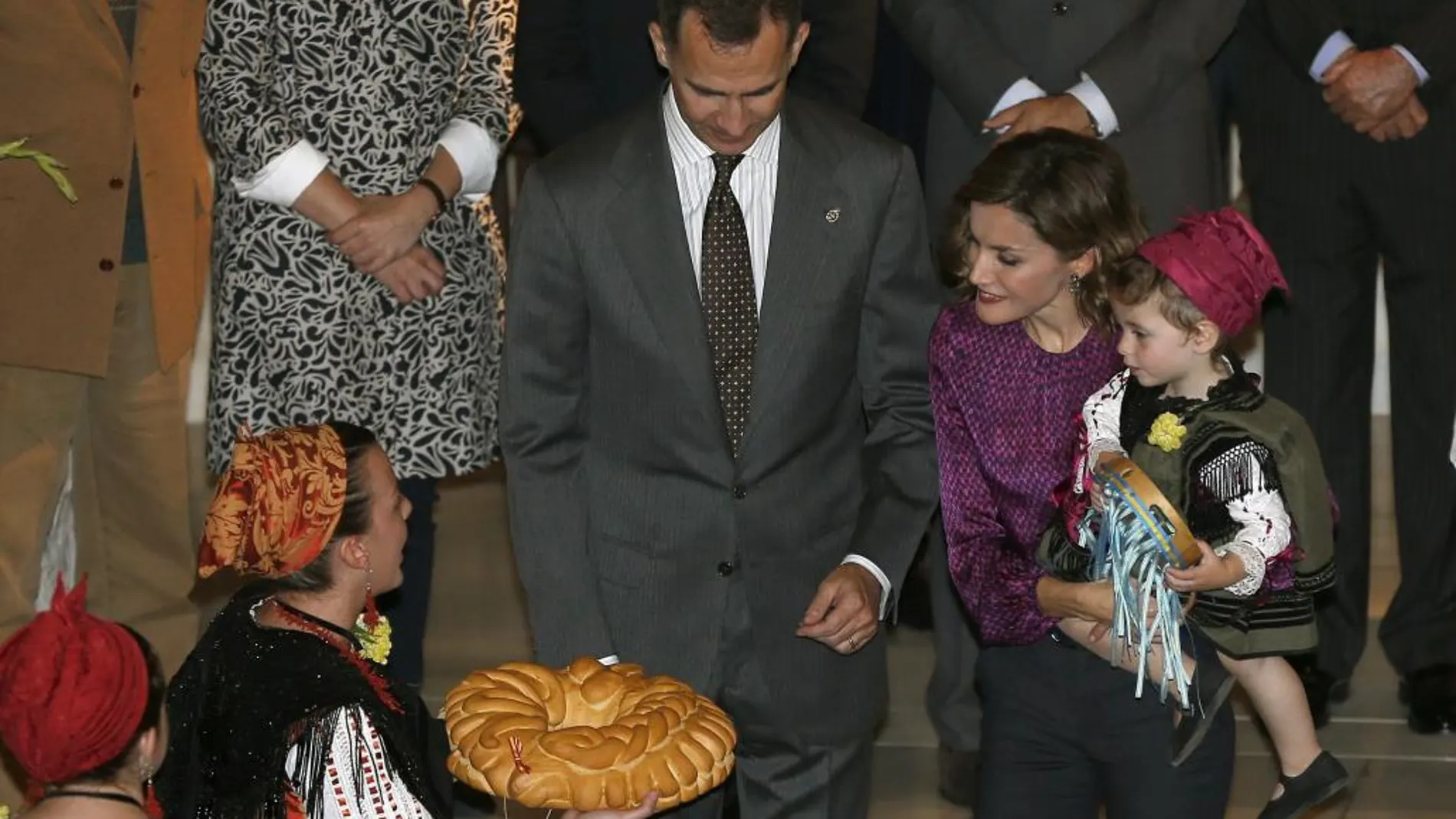 Los Reyes Felipe y Letizia reciben de obsequio una empanada durante su visita hoy a la localidad asturiana de Colombres