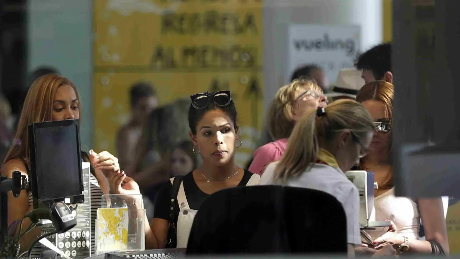 Personal de facturación de Vueling atiende a los viajeros en el Aeropuerto de El Prat.