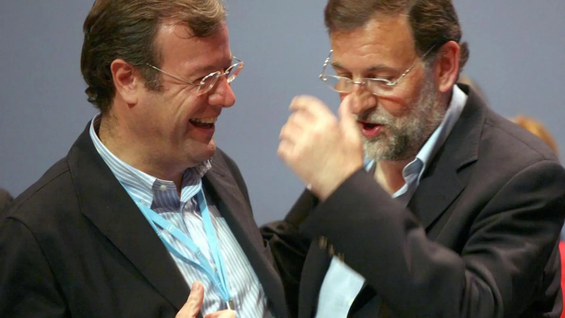 Antonio Silván y Mariano Rajoy, conversan animadamente, durante un encuentro del PP en Valladolid