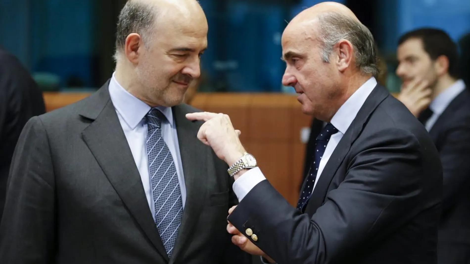 El comisario europeo de Asuntos Económicos, Pierre Moscovici, conversa con el ministro español en funciones de Economía, Luis de Guindos.