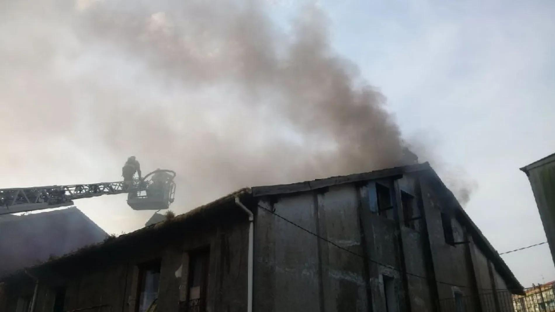 Imagen de un bombero en una escalera intentando acercarse al origen del fuego