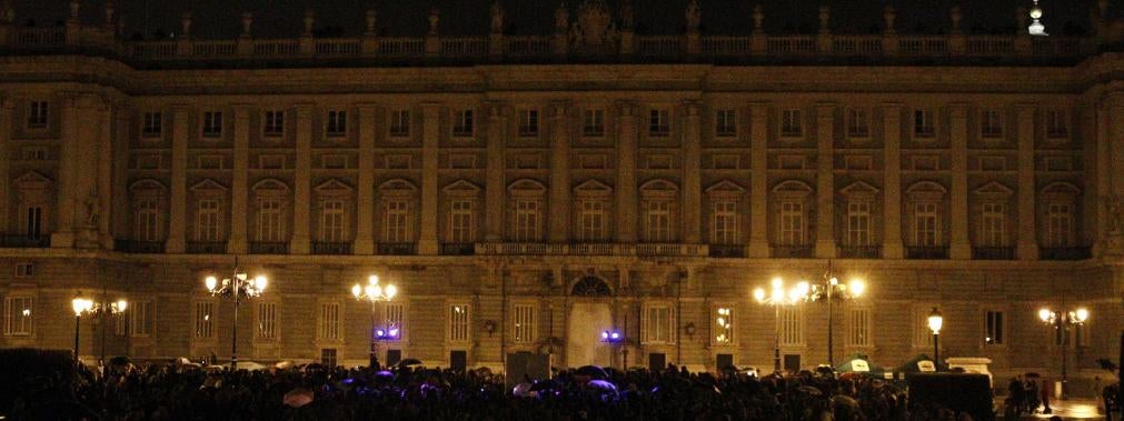 Combo de fotografías del Palacio Real de Madrid antes y después del apagado de luces 