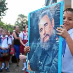 Un estudiante de un colegio sostiene un cartel con la imagen de Fidel Castro en un homenaje en La Habana al fallecido dictador