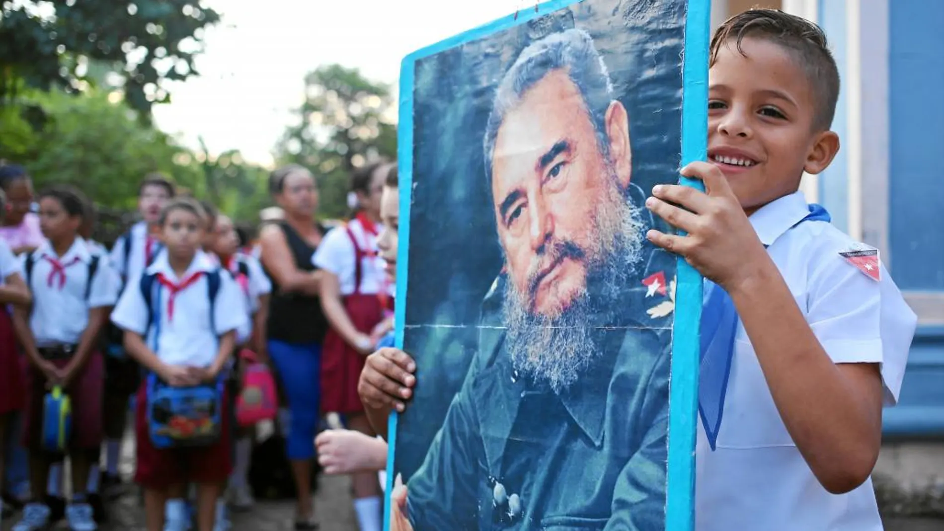 Un estudiante de un colegio sostiene un cartel con la imagen de Fidel Castro en un homenaje en La Habana al fallecido dictador