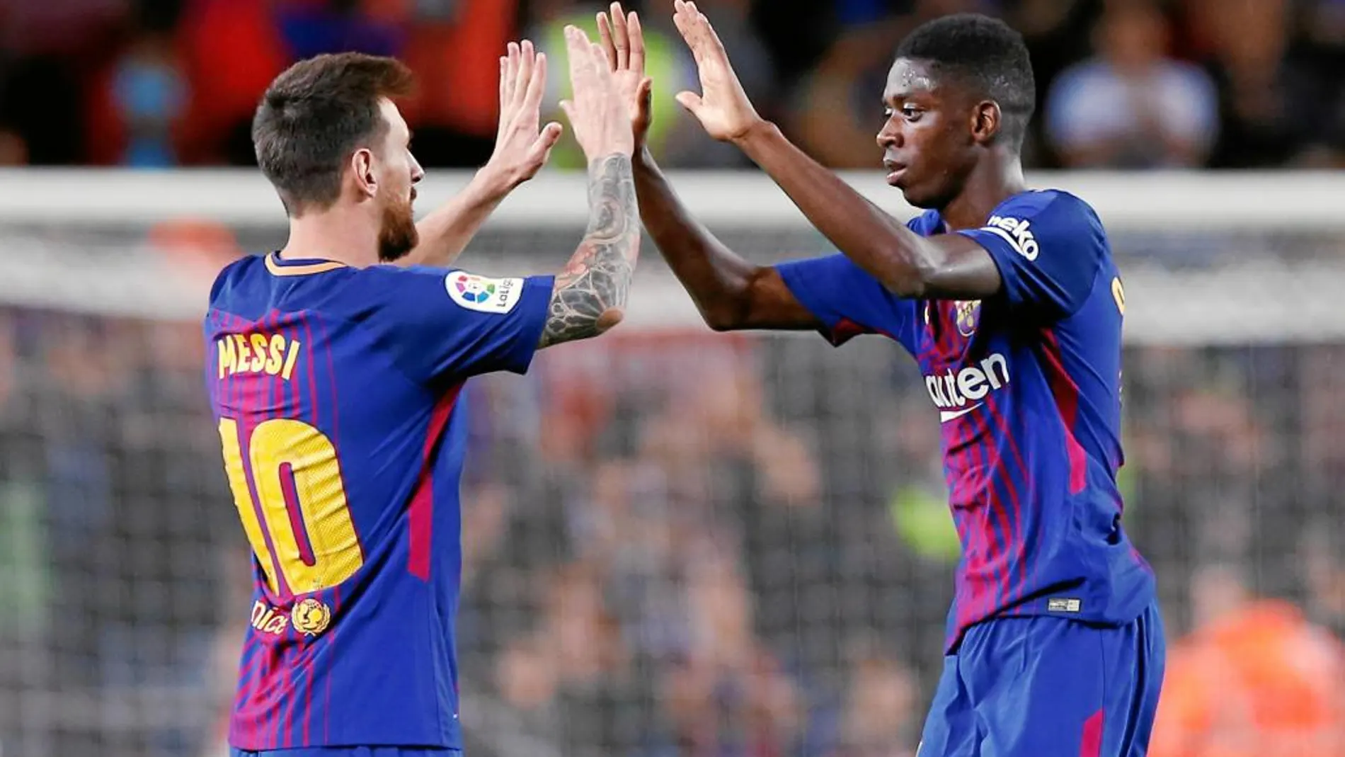 Messi y Dembélé chocan sus manos durante el partido de ayer en el Camp Nou
