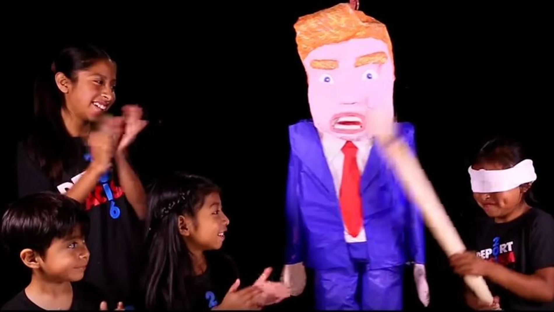 Fotograma del vídeo en el que niños hispanos juegan con una piñata que representa la figura de Trump
